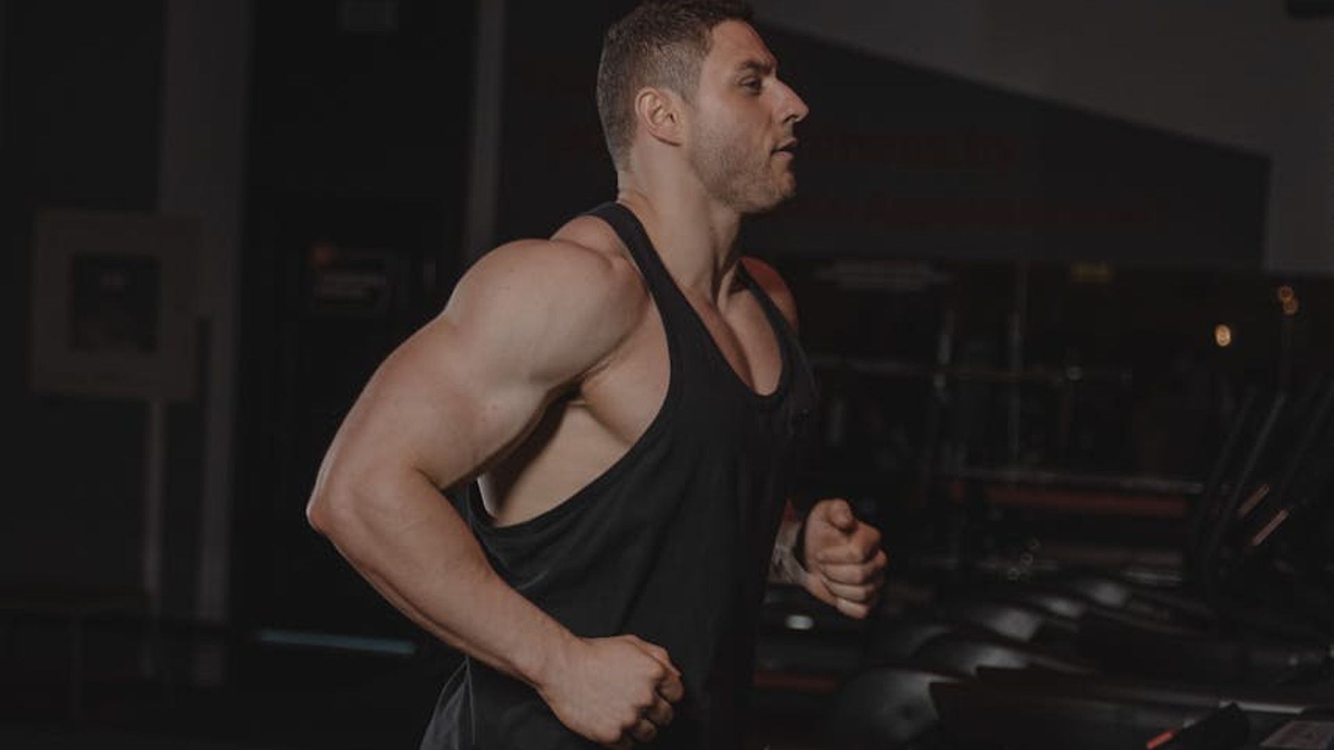 Athletic person performing dynamic cardio exercises in a bright gym.