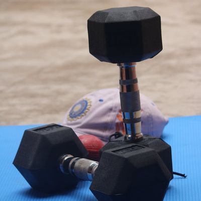 Black dumbbells lying on a gray exercise mat.