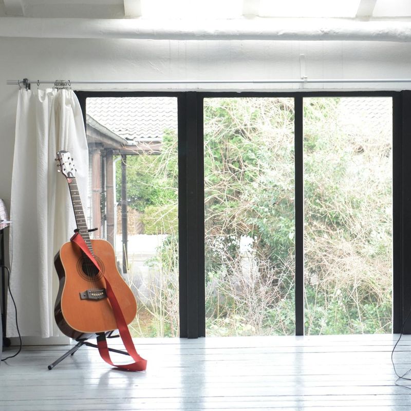 Minimalist training studio with wooden floors and large windows.